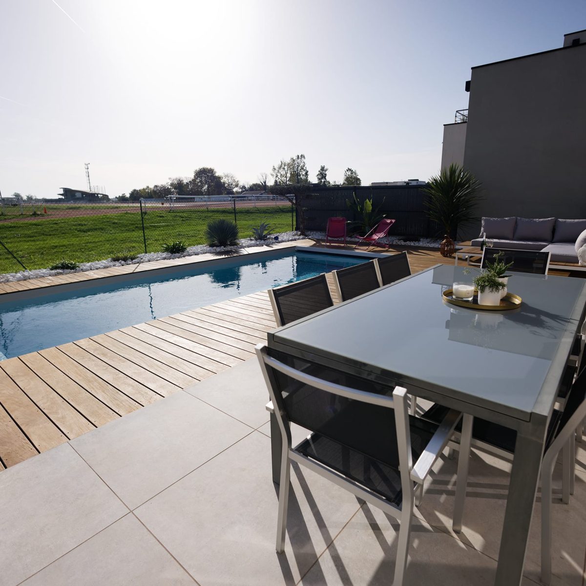 Piscine 8,00 x 3,00 m à fond plat, margelles et plages en bois, volet immergé